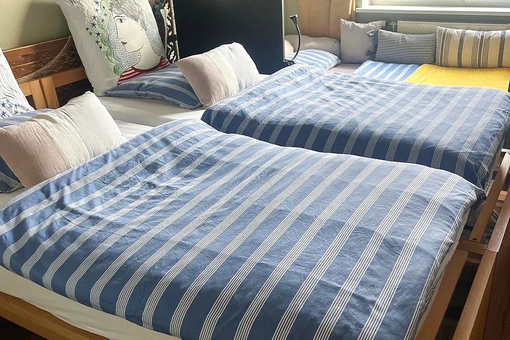 Chambre avec lits doubles habillés de linge rayé bleu et blanc