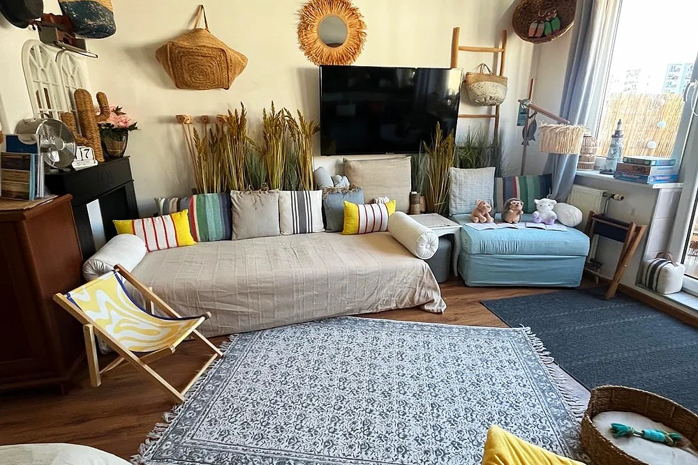 Salon lumineux avec canapé beige, coussins rayés et décoration bohème