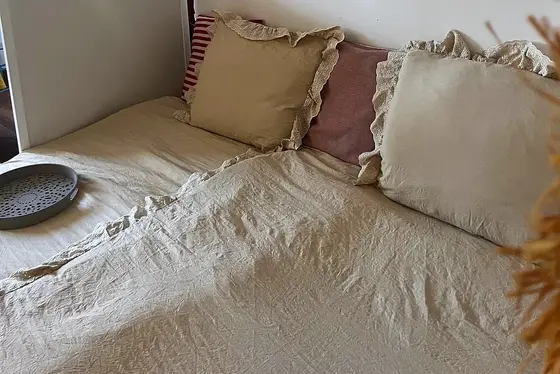 Détail de coussins en lin sur le lit